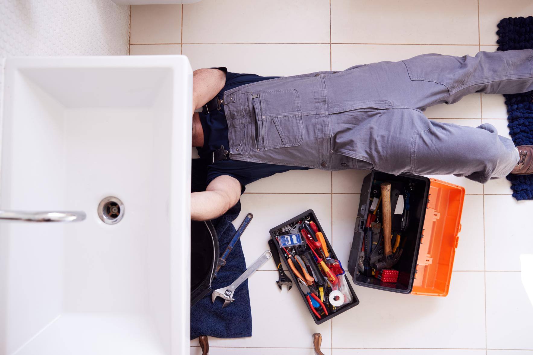 commercial-plumber-working-under-sink