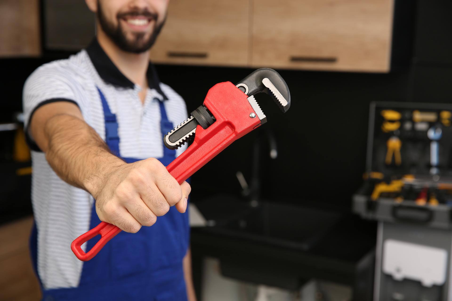 residential-237409223-male-plumber-holding-pipe-wren